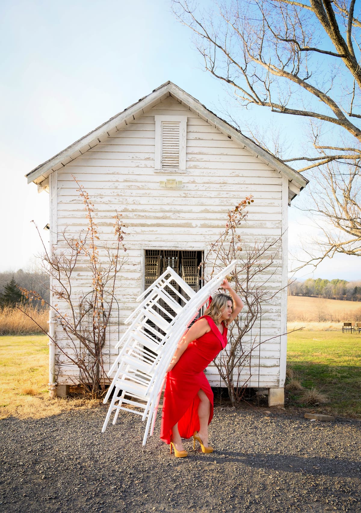 Isadora Martin-Dye carrying a stack of Chiavari chairs at Rixey Manor
